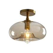 Modern DecorBites™ LED glass ceiling light with brass finish and amber glass globe for contemporary spaces