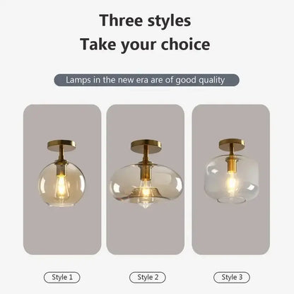 Three modern decorbites led glass pendant ceiling lights with brass fixtures and clear and amber spherical shades