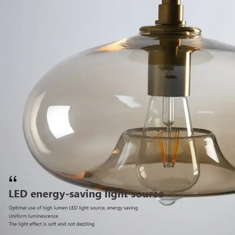 A modern DecorBites led glass ceiling light with translucent amber shade brass hardware and exposed LED filament bulb