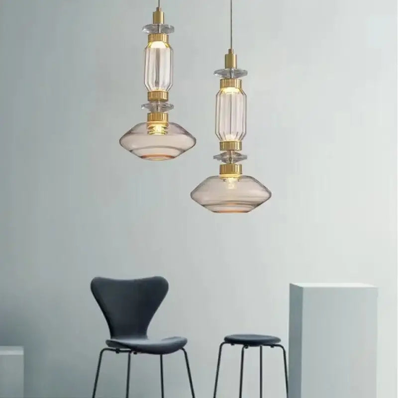 Two elegant DecorBites LED glass chandelier pendant lights with clear amber glass and gold-toned metal accents hang elegantly