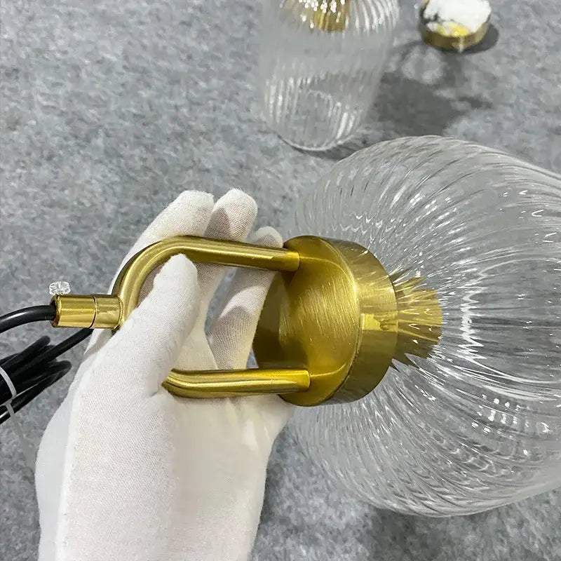 Gold-toned metal fixture with clear ribbed glass globe in decorbites led glass chandelier for modern dining room lighting