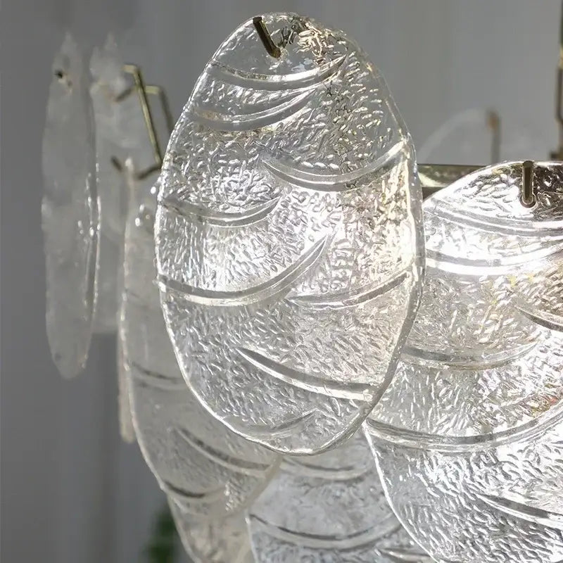 Clear textured glass fish-shaped pendant with intricate etching and metallic hook in decorbites led glass chandelier design
