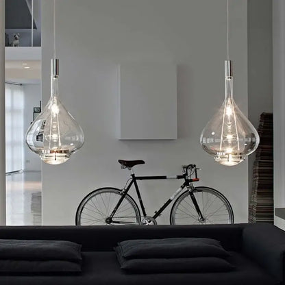 Two clear glass decorbites led glass pendant chandelier lights with metallic fixtures hanging from the ceiling Italy design
