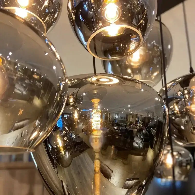 A modern DecorBites™ LED glass pendant chandelier with multiple reflective spherical glass shades for kitchen décor