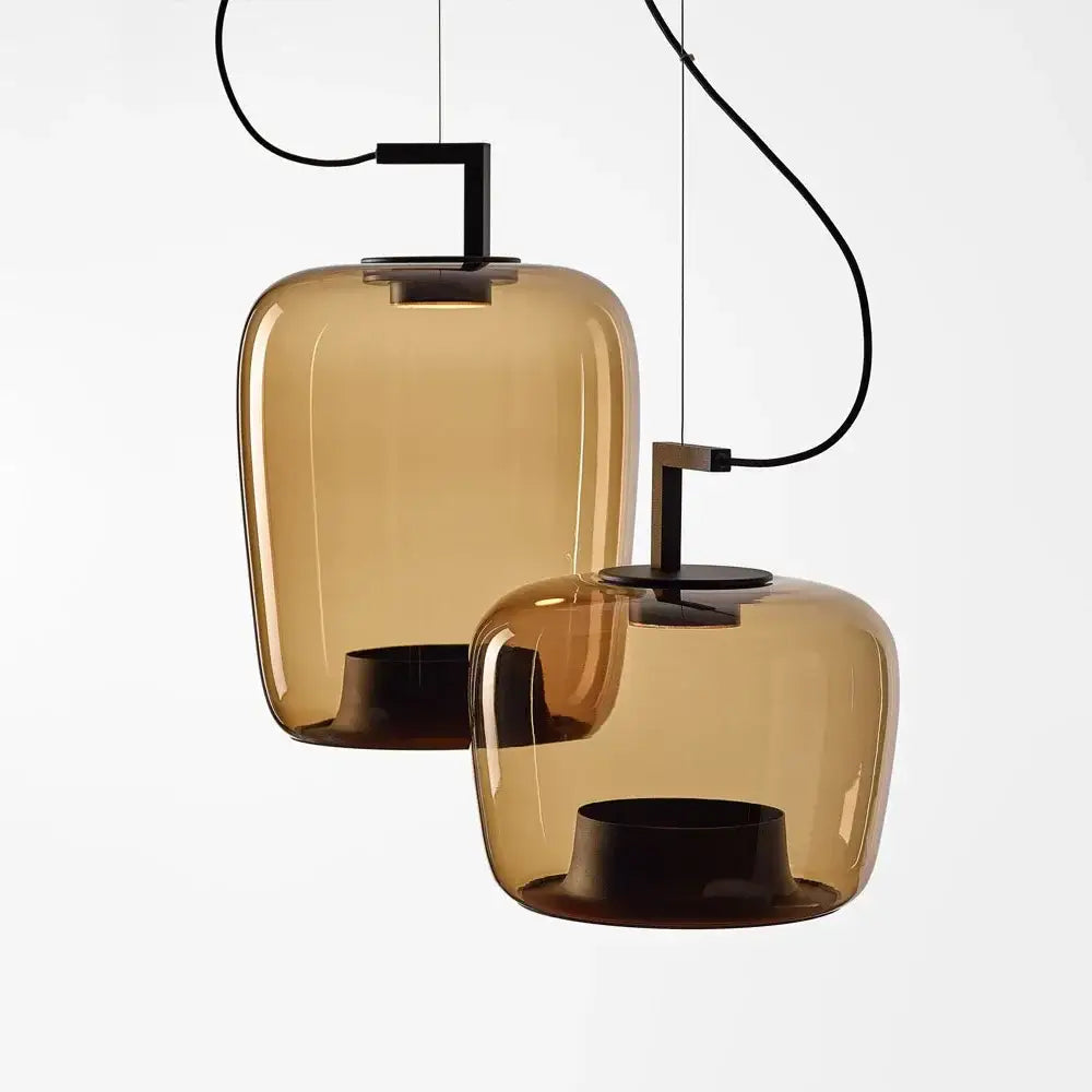 Two amber-tinted glass led glass pendant lights with black metal fixtures in the DecorBites led glass pendant chandelier