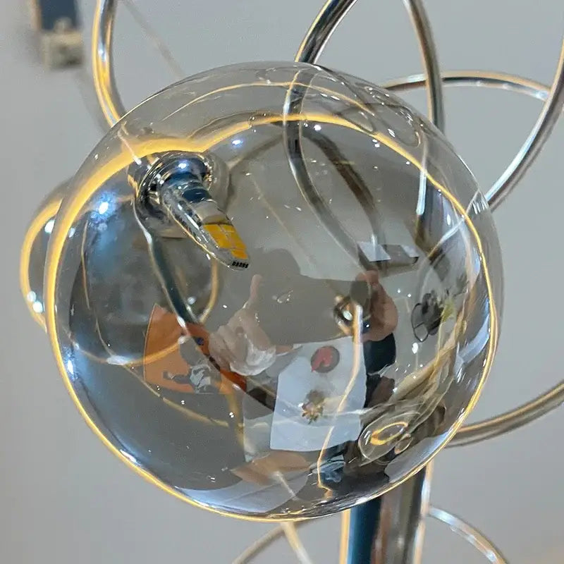 Chrome finished spherical decorbites led glass pendant chandelier with clear globe and metallic arm for living room use