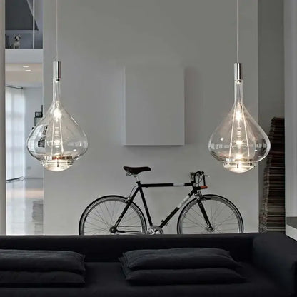 Two elegant teardrop shaped led glass pendant lamps with metallic fixtures for hotel kitchen restaurant bar lighting