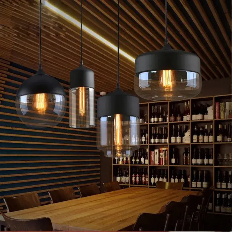 Decorbites led glass black metal pendant lamp with clear shades and exposed filament bulbs above wooden table