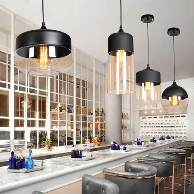 Black metal decorbites led glass pendant lamp with clear glass shades and exposed filament bulbs above a bar area