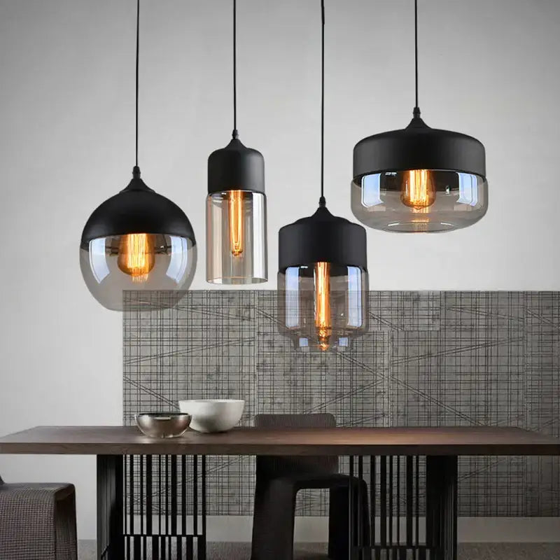 Three modern decorbites led glass pendant lamps with black metal tops and smoked glass shades for stylish indoor lighting