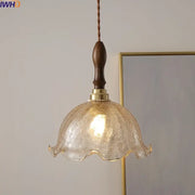 A warm-toned textured glass pendant light with dark wood handle and brass accents decorbites led glass chandelier