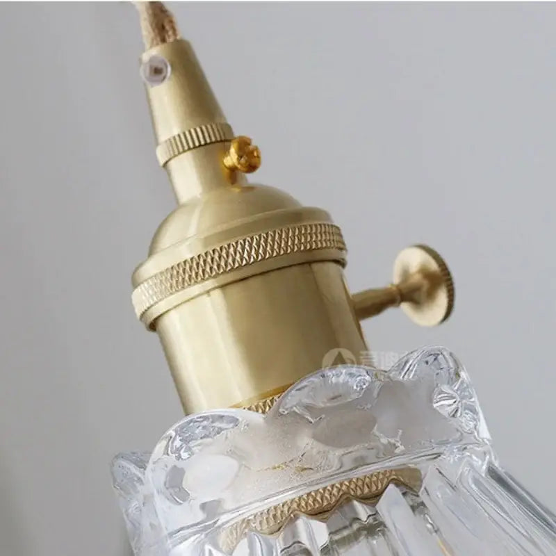 Gold-toned brass decorbites led glass pendant light with ridged bands and clear faceted crystal shade for modern decor