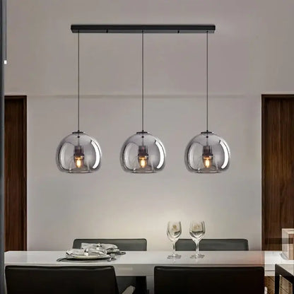 Modern nordic luxury decorbites led glass pendant light with black metal bar and transparent spherical shades encasing warm bulbs