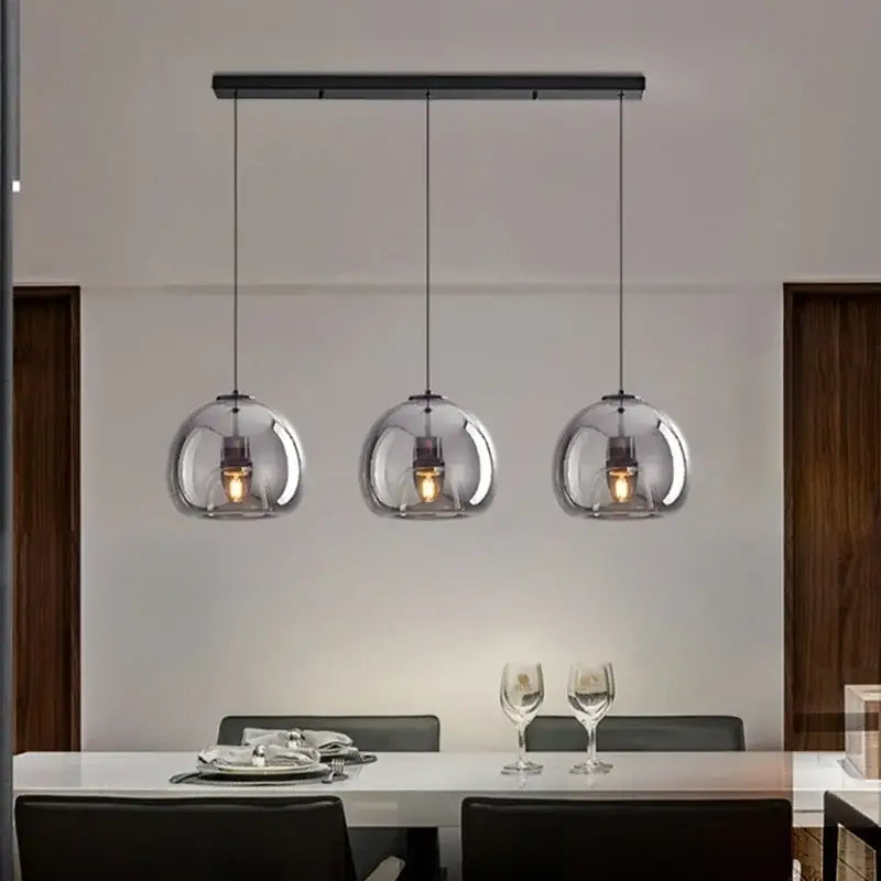 Modern nordic luxury decorbites led glass pendant light with black metal bar and transparent spherical shades encasing warm bulbs