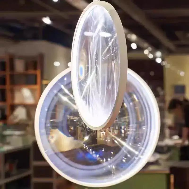 A modern round decorbites led glass pendant light with clear glass lens and frosted white frame for hall or living room