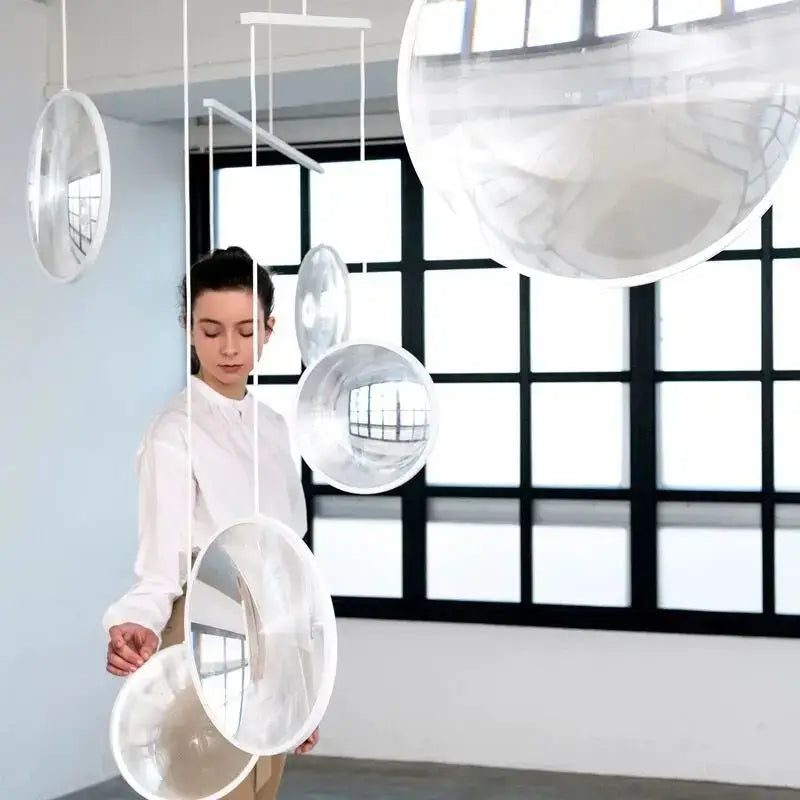 Clear transparent spherical glass pendant light suspended by white cords from ceiling decorbites led glass fixture