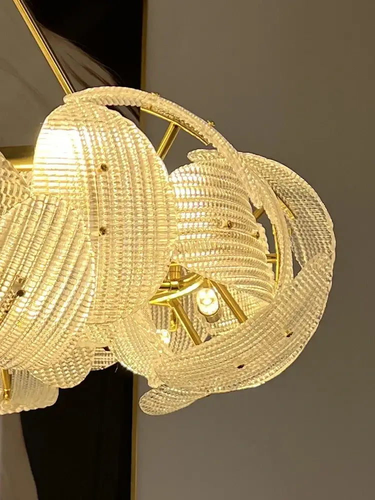 A golden-framed decorbites led glass petal chandelier with layered crystal petals for luxury dining table lighting