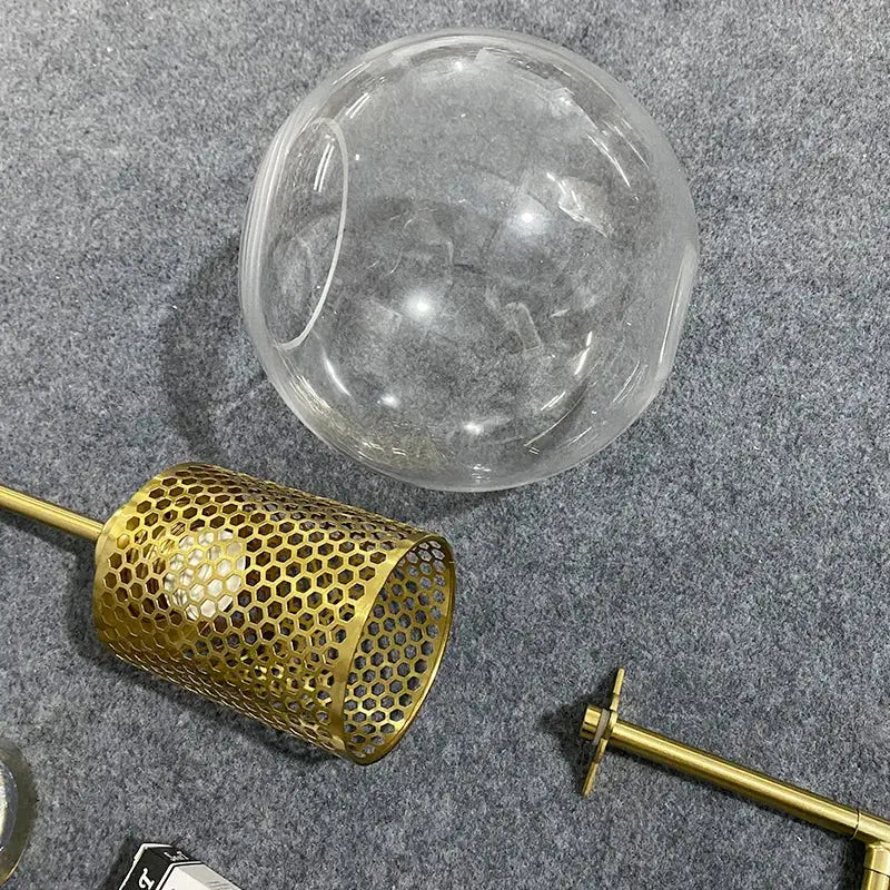 Decorbites led glass wall lamp with clear glass globe, gold honeycomb mesh shade, and brass hardware for modern bedroom decor