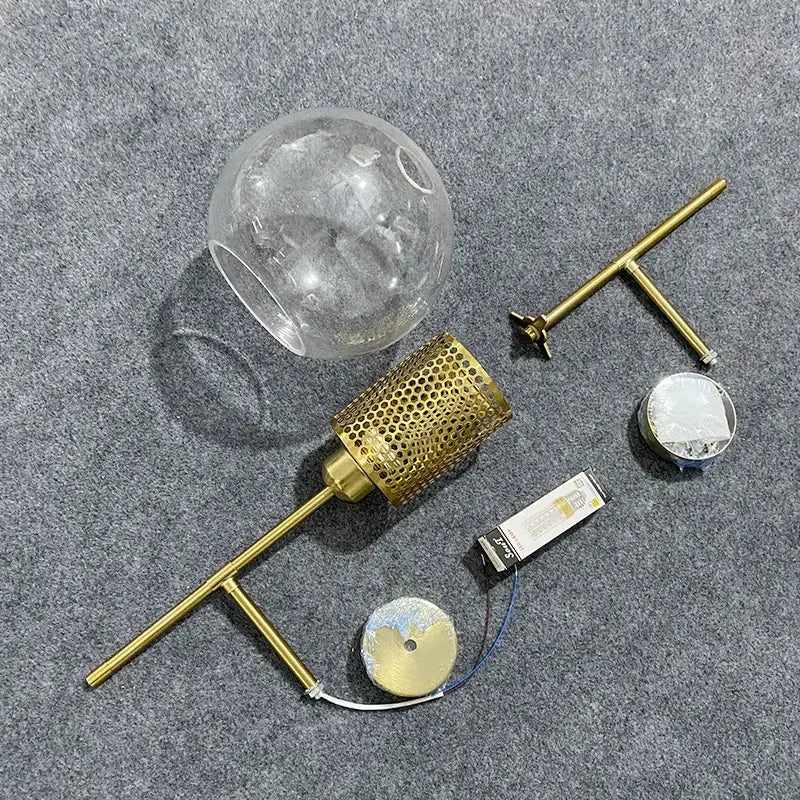 Gold-toned brass DecorBites led glass wall lamp with clear glass globe shade and perforated metal diffuser for modern decor