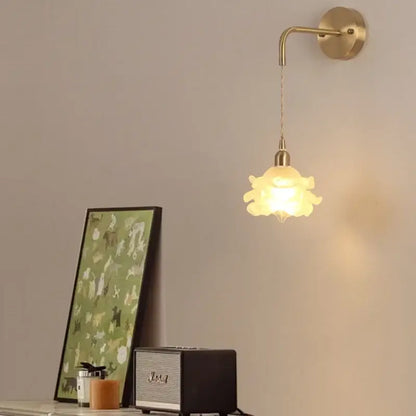 A warm-toned led glass wall lamp with petal design and brass mount by decorbites for modern bedroom decor