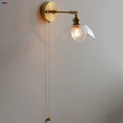 Gold-toned DecorBites™ LED wall light fixture with textured glass flower shade and adjustable pull-chain switch for living room use