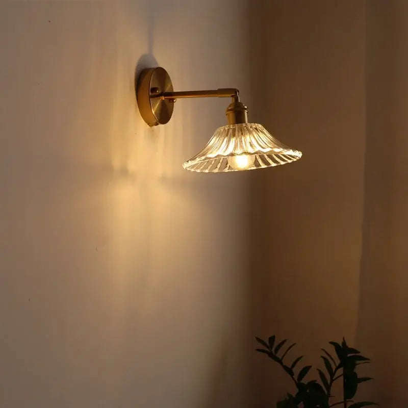 Brass-finished decorbites led glass wall light with fluted clear glass shade emitting warm light for modern decor