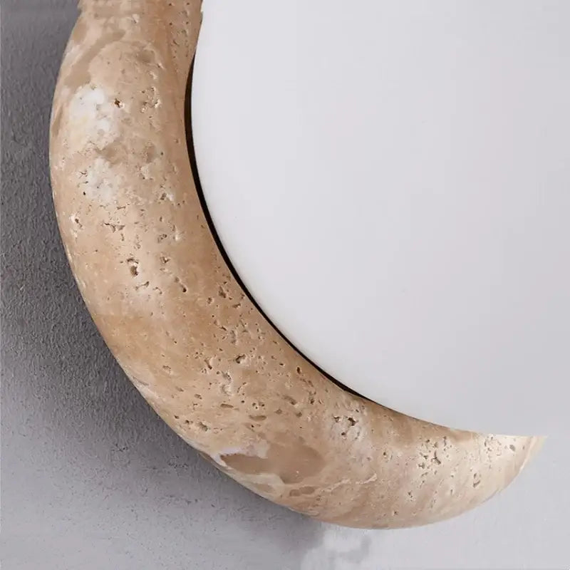 Beige stone crescent wall mirror with textured natural finish paired with decorbites led glass wall lights for living room