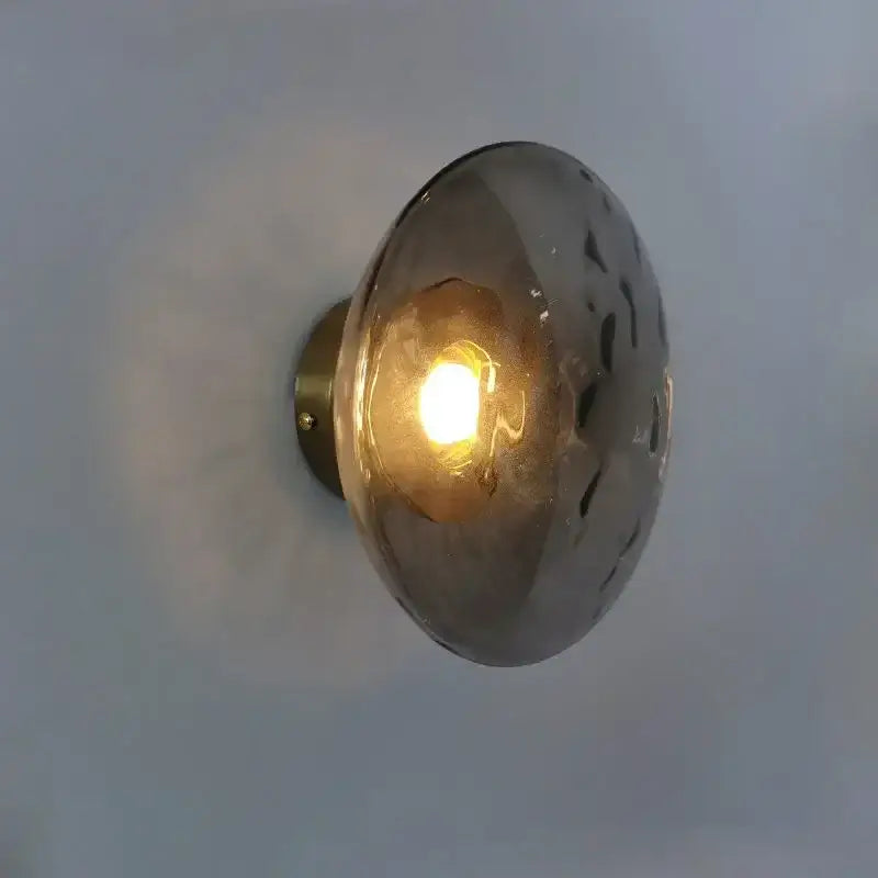 Warm-toned decorbites led glass wall sconce with hammered texture and brass mounting for living room lighting