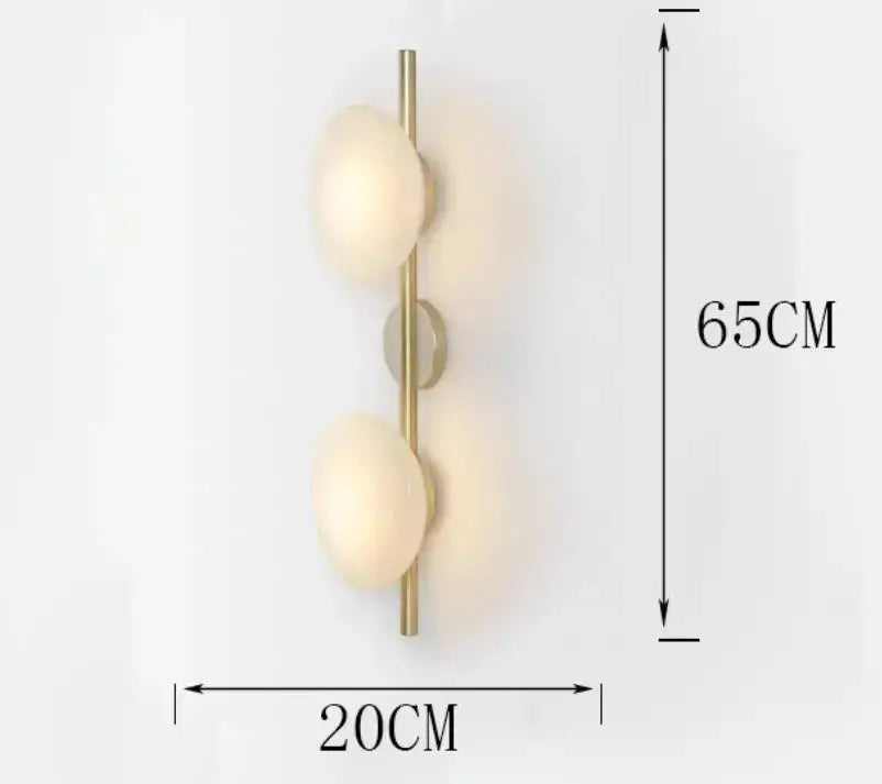 A modern decorbites led glass wall sconce with two frosted glass globes on a brass vertical bar for living room lighting