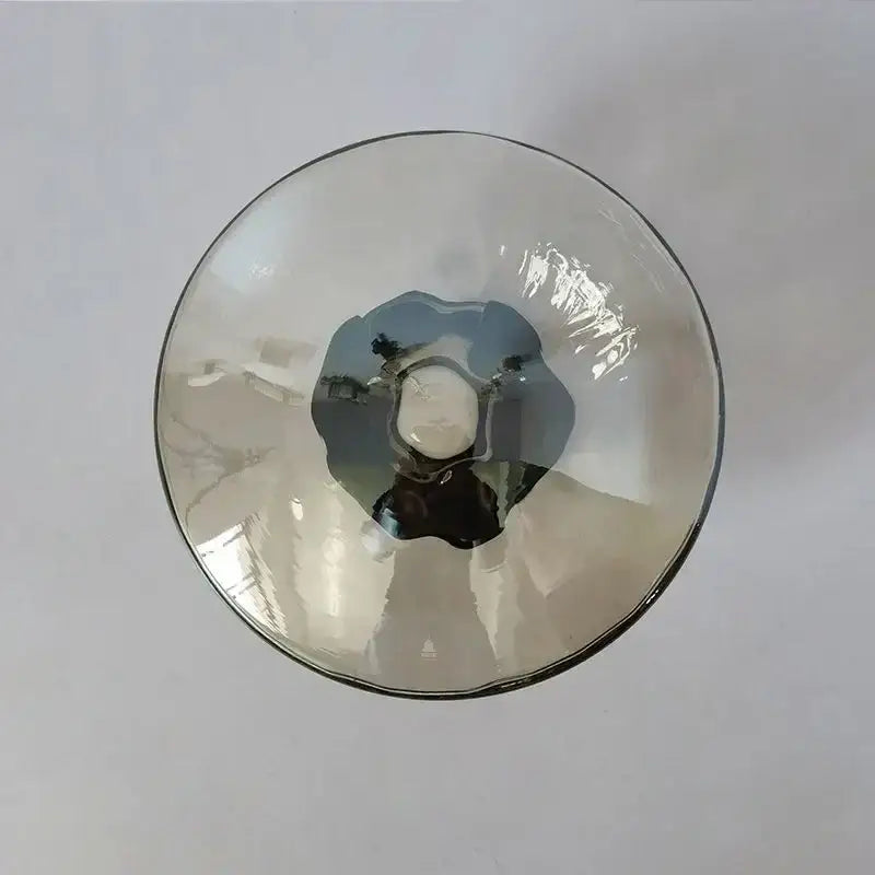 A translucent gray glass bowl with a smooth rim and textured interior in DecorBites LED glass wall sconce for living room