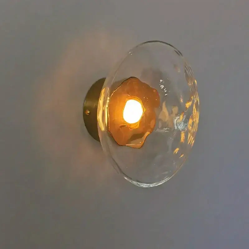 Clear textured glass globe wall sconce with warm amber LED light and brass plate by DecorBites LED glass for living room