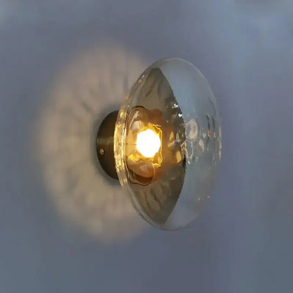 A warm-toned hammered glass dome wall sconce with brass backplate from decorbites led glass for living room lighting