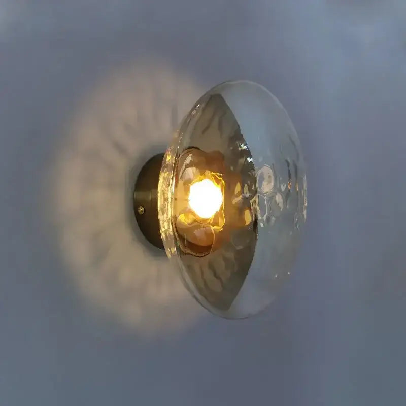 A warm-toned hammered glass dome wall sconce with brass backplate from decorbites led glass for living room lighting