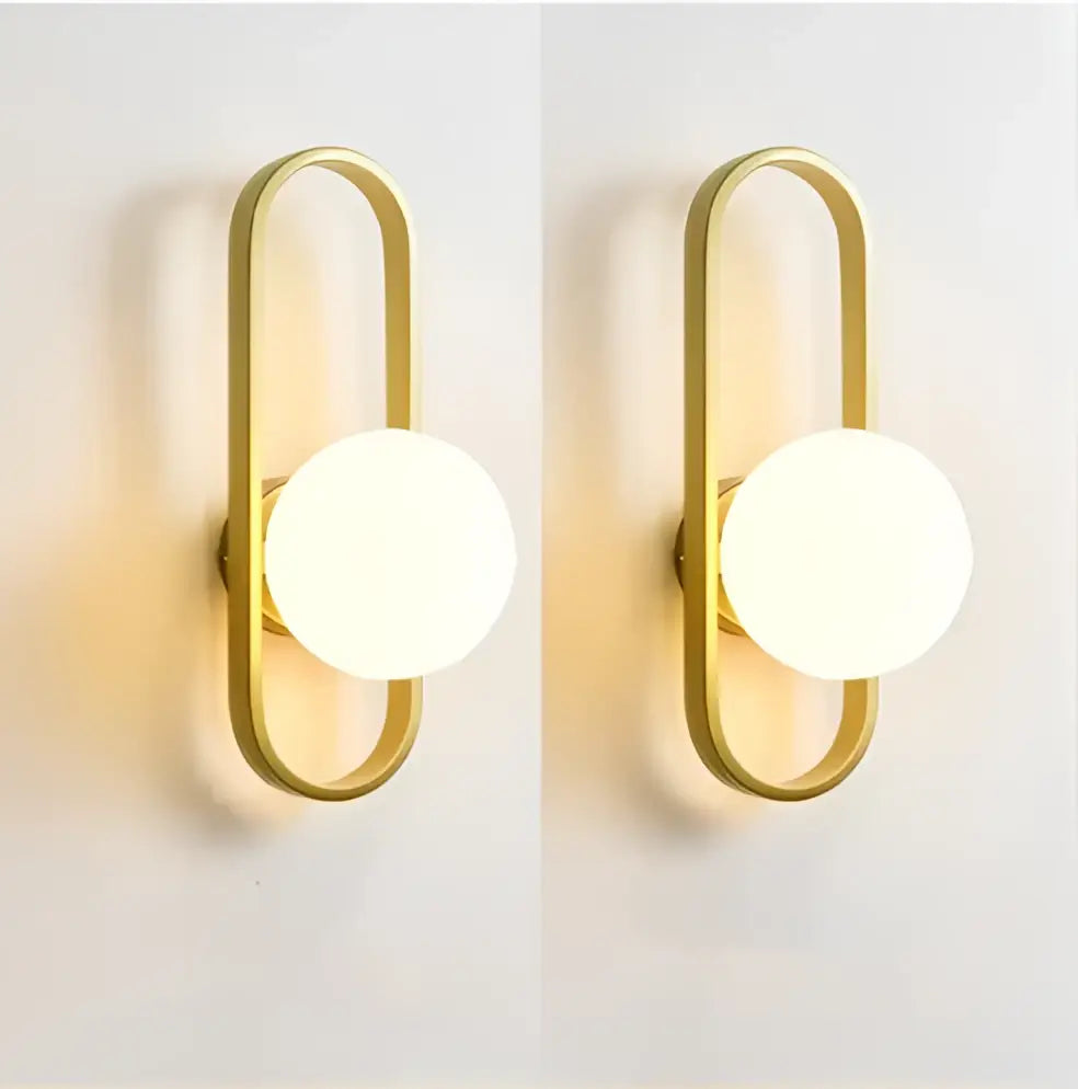 Gold-toned minimalist DecorBites™ LED wall sconce lamp with elongated oval frame and white glass shade for bedroom or staircase