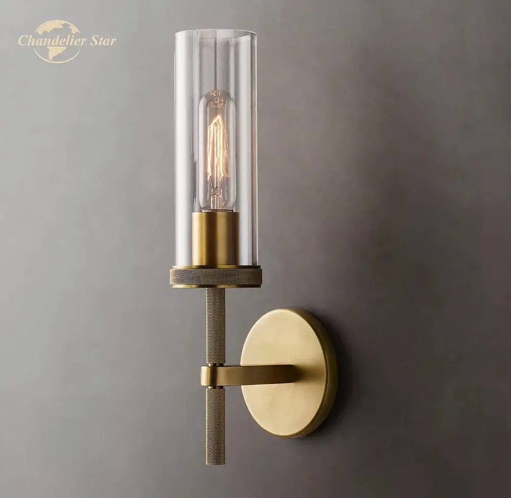Brass-finished decorbites led glass wall sconce with clear glass cylinder and exposed filament bulb for indoor use