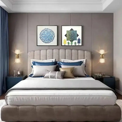 Beige tufted upholstered bed with blue gray gold pillows complemented by gold decorbites™ led glass wall sconces for home lighting