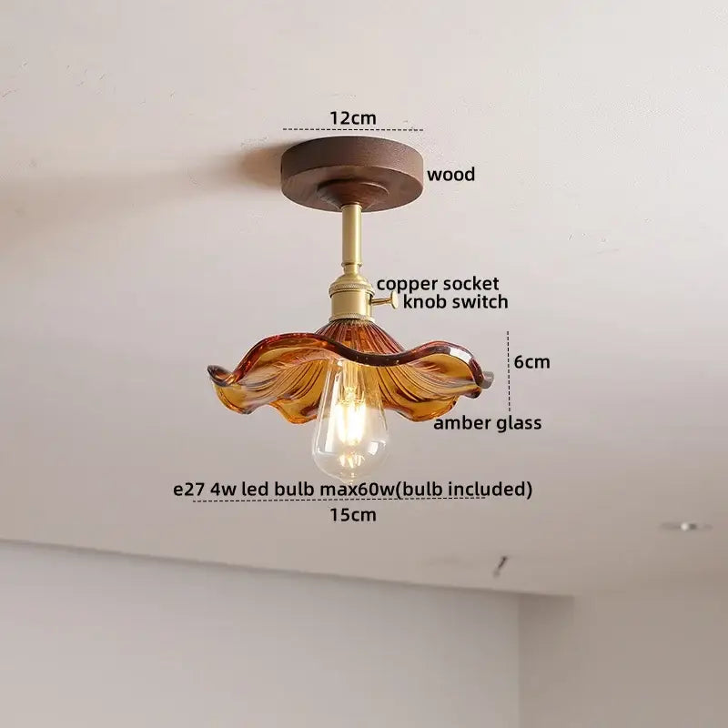 A warm amber decorbites led glass wood ceiling lamp with copper socket and wooden base featuring wavy design