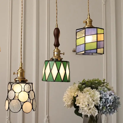 Three hanging decorbites led glass and wood pendant lamps with vintage copper fixtures and geometric colored patterns