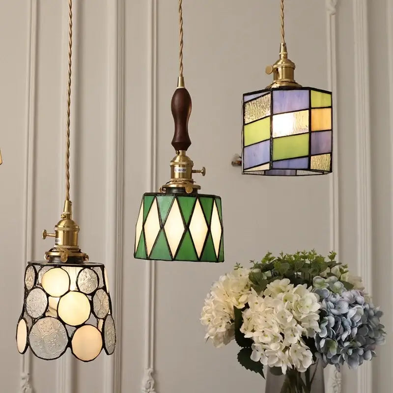 Three hanging decorbites led glass and wood pendant lamps with vintage copper fixtures and geometric colored patterns