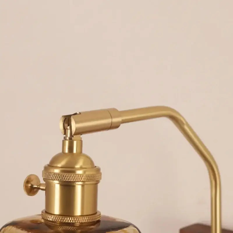 Gold-toned brass DecorBites™ LED glass and wood wall lamp with curved arm and knurled base for living room and bedroom
