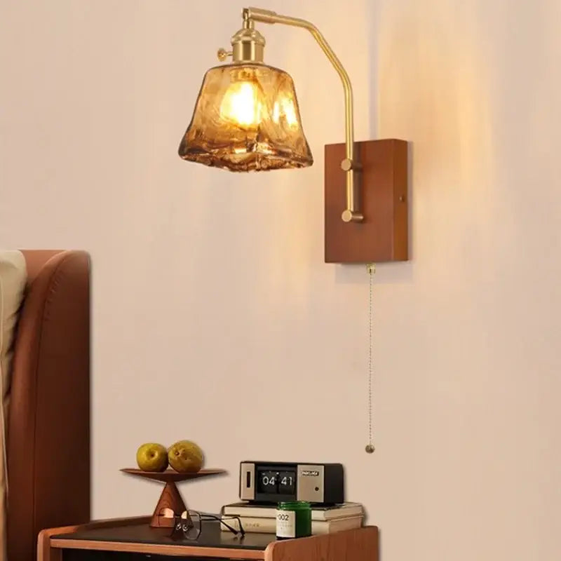 Brass-finished DecorBites LED wall lamp with textured amber glass shade and wooden backplate for living room use