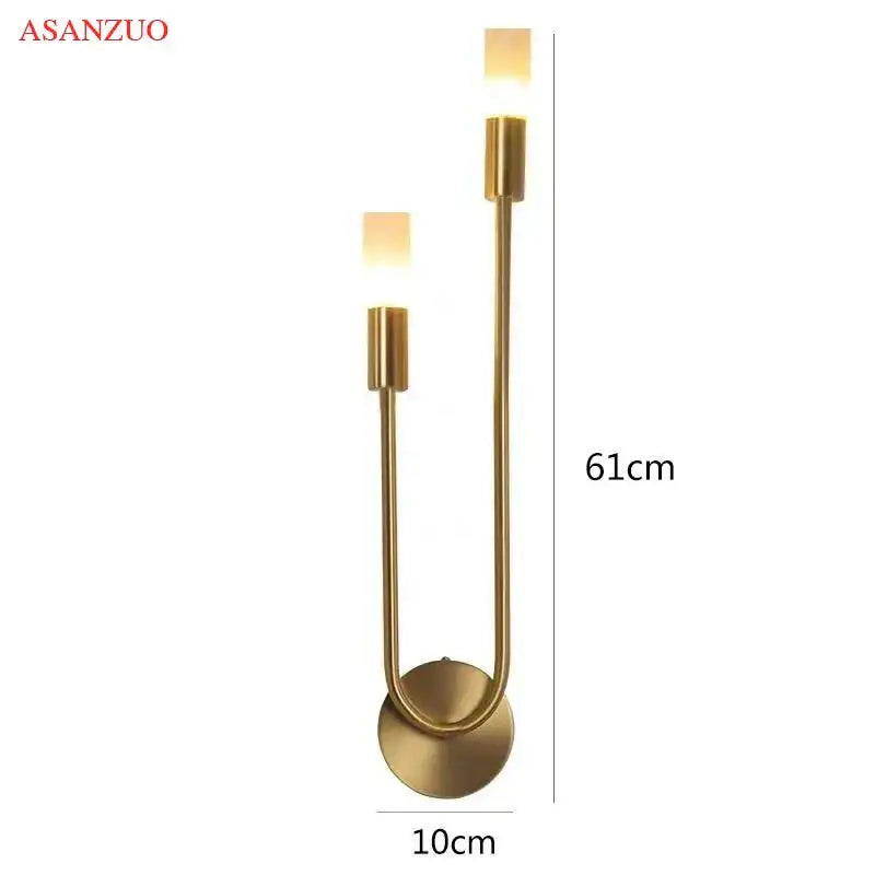 Gold-toned decorbites led candlestick wall light with two upward cylindrical fixtures and curved metal base for indoor decor
