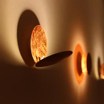 Decorbites led gold eclipse wall lamp warm-toned circular sconce with golden-brown metallic finish and black accent plate