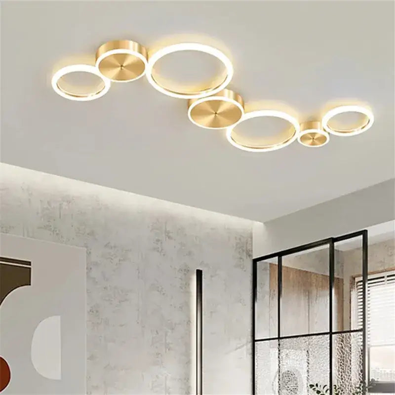 Modern gold-toned decorbites led gold ring chandelier with illuminated circular rings for living room and bedroom lighting