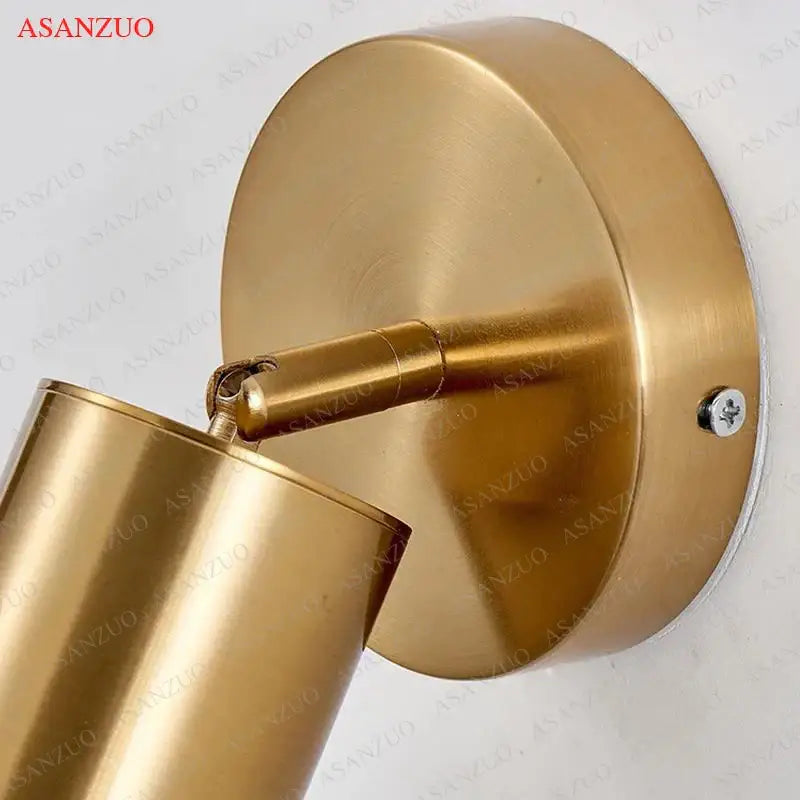 Brass-finished decorbites led gold wall lamp with adjustable cylindrical head and round mounting plate for bedroom use