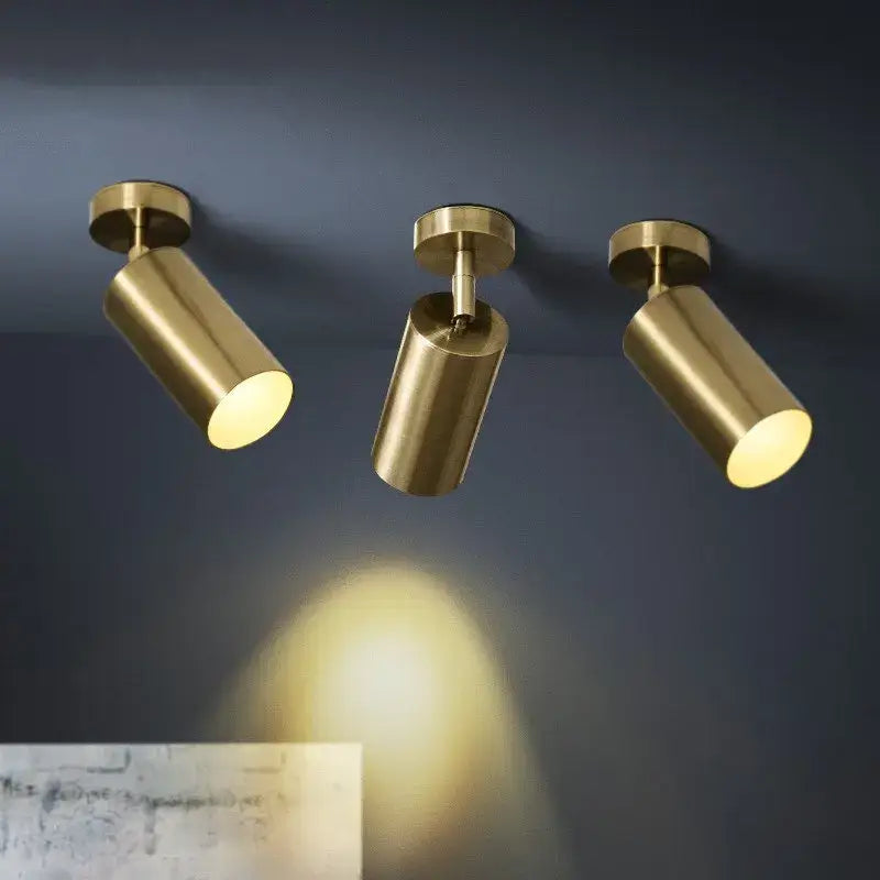 Decorbites led golden ceiling light featuring three modern brass-finished adjustable spotlights mounted on a dark wall