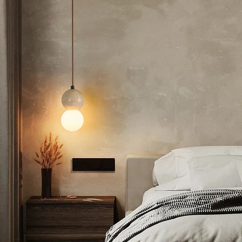 A decorbites led gourd pendant light with a frosted white glass globe and yellow travertine hanging from a metal chain