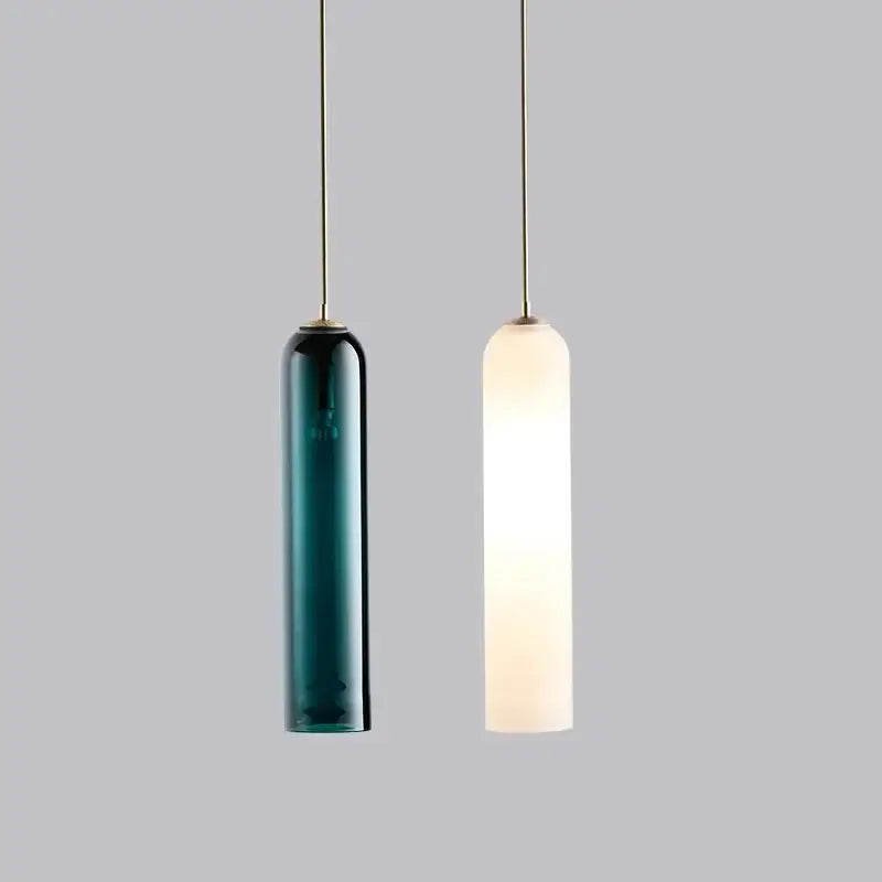 Two modern pendant lights with decorbites led green glass and opaque shades suspended by brass cords for kitchen bar decor