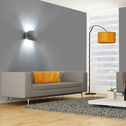Gray modern sofa with orange throw pillows next to decorbites led gypsum wall sconce 5W for bedroom and living room decor