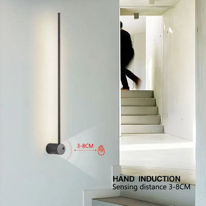 A sleek minimalist decorbites led hand induction wall light with vertical rod and cylindrical base for corridor and bedroom